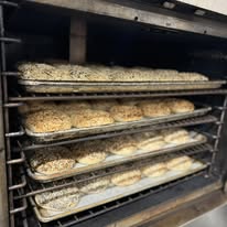Racks of seeded bagels baking in the commercial oven at Bonnie's