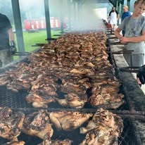 Massive grill loaded with chicken halves at Bonnie's annual BBQ community event