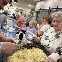 Volunteers serving food at a community dinner organized by Bonnie's