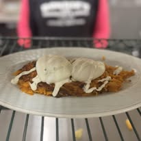 Eggs benedict on hash browns with drizzle at Bonnie's